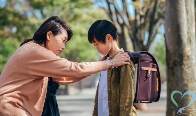 子どもを集会に連れて行こうとする親