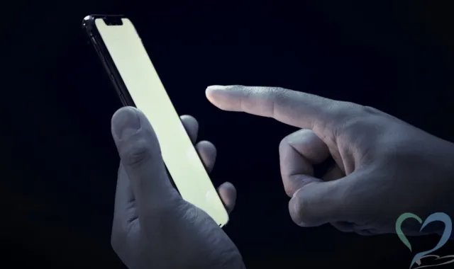 暗闇でスマホを操作する手