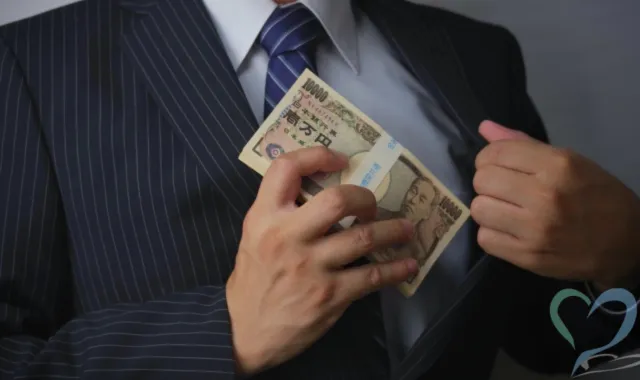 お金を懐に入れる男性