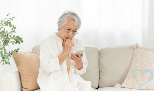 携帯を持って悩む女性