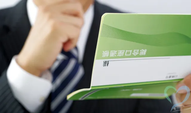 通帳を見て悩む人